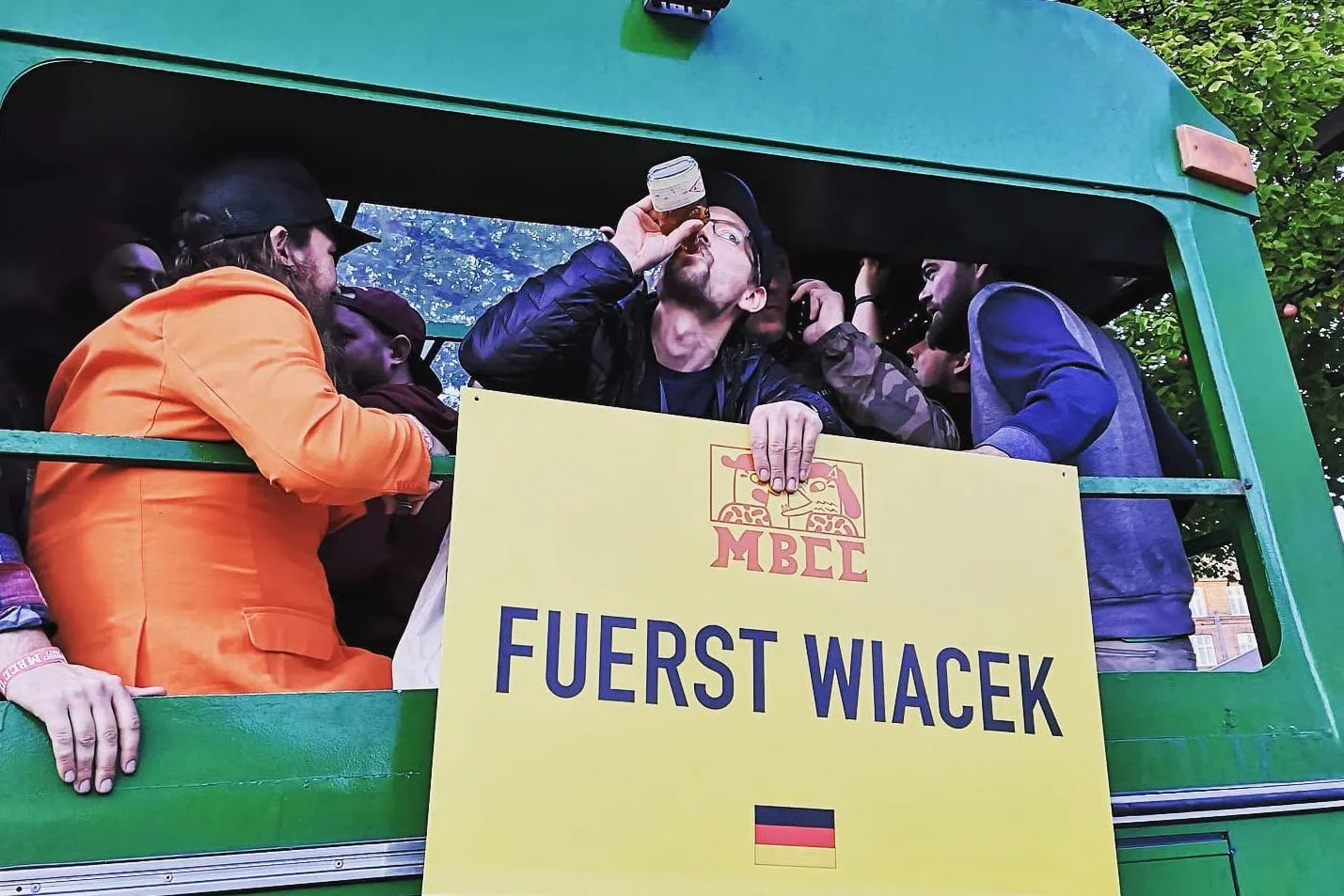 Bierfest in der Fuerst Wiacek Brauerei, Menschen genießen Craft Beer auf einem LKW im Freien mit einem Fuerst Wiacek-Schild und einer deutschen Flagge, lebhaftes Brauereievent, Craft Beer Verkostungserlebnis.