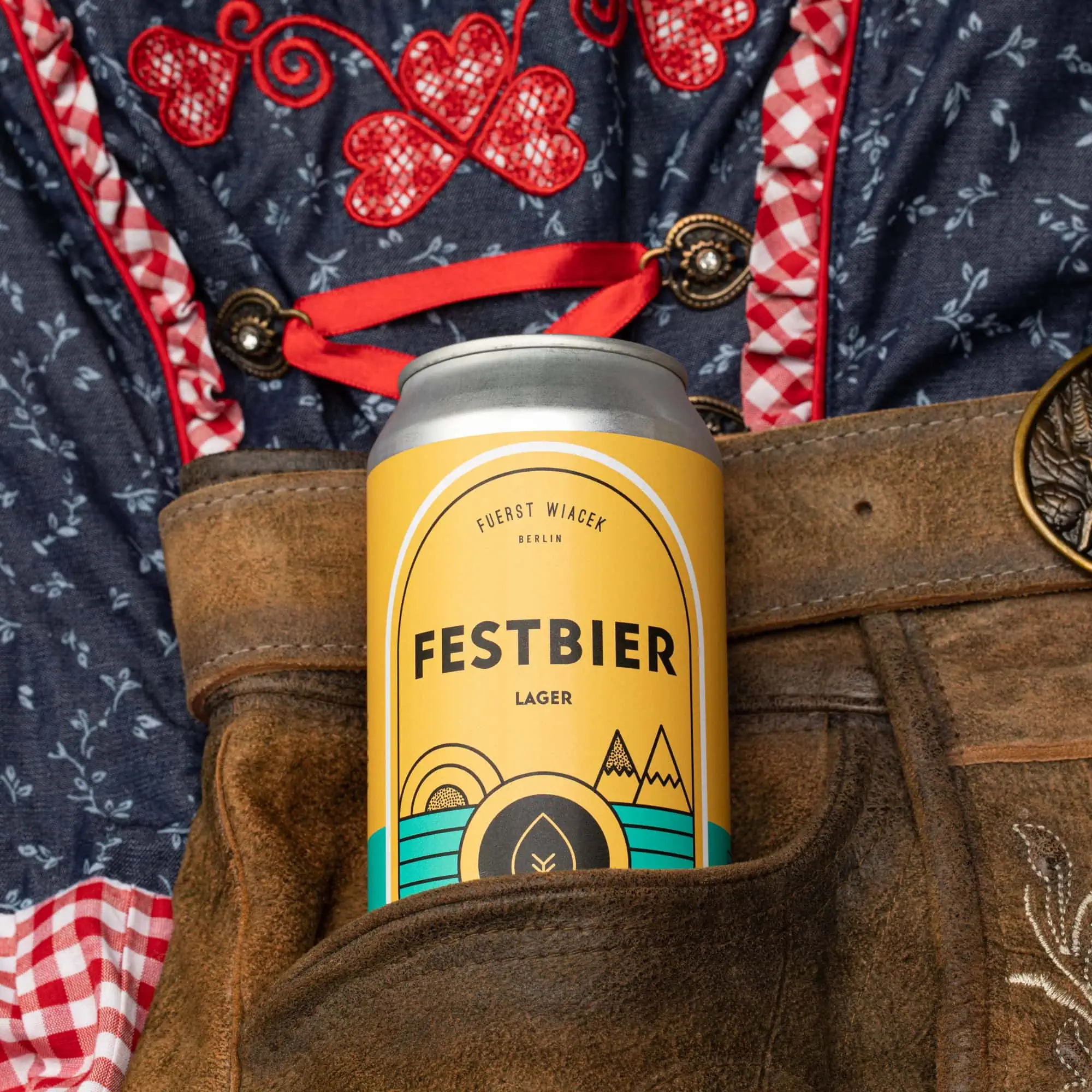A can of Fuerst Wiacek Festbier Lager in a traditional German-style leather beer stein pocket, showcasing brewery branding and craftsmanship.