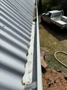 Arial photo of metal roof gutters with half cleaned by G2G gutters and other half still with leaves