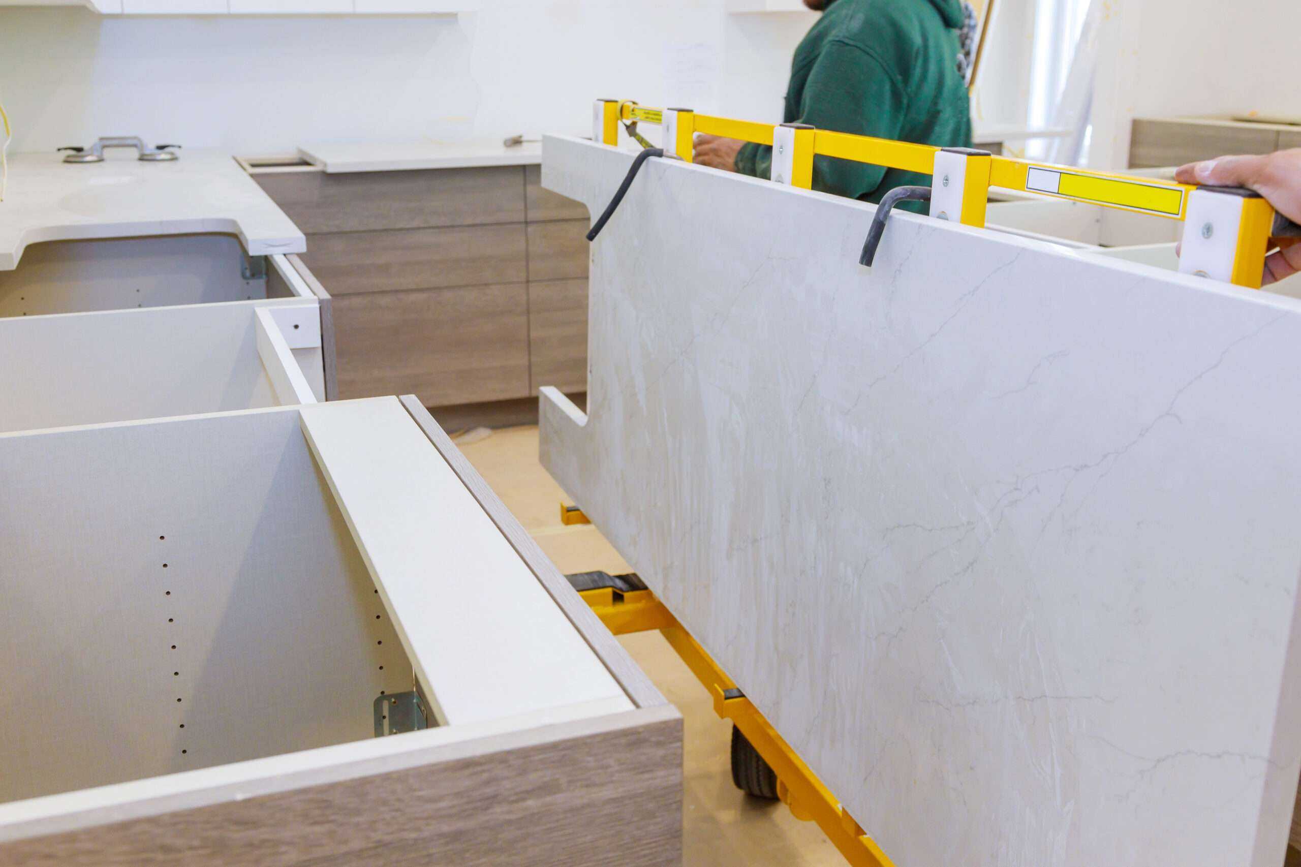 Trabajador moviendo una pesada losa de mármol en la remodelación de una cocina - Abogado de Boston especializado en lesiones por caídas de losas de piedra
