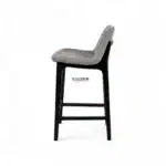 Modern upholstered bar stool with fabric seat and black wooden legs for stylish kitchen decor.