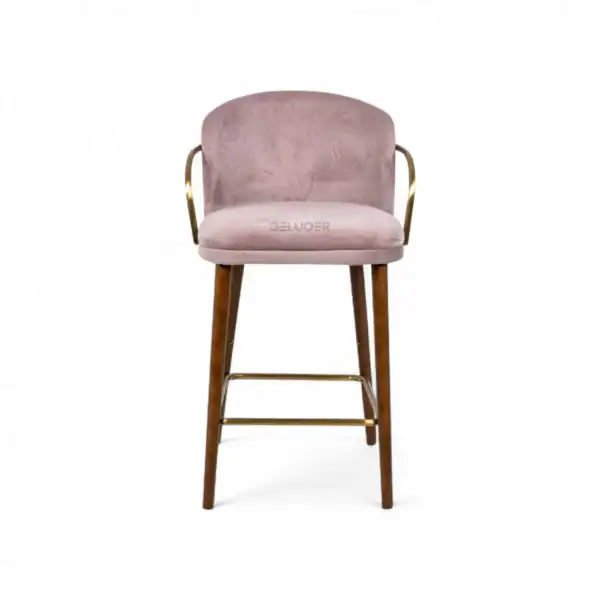 Elegant pink velvet bar stool with wooden legs and gold metal accents for modern home decor.