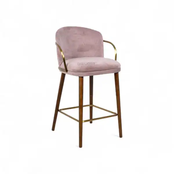 Luxurious pink velvet bar stool with gold metal armrest and wooden legs, perfect for modern interiors.