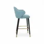 Comfortable blue upholstered bar stool with black wooden legs and gold footrest.