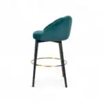 Luxurious emerald green velvet bar stool with black wooden legs and gold footrest, perfect for modern dining or bar areas.