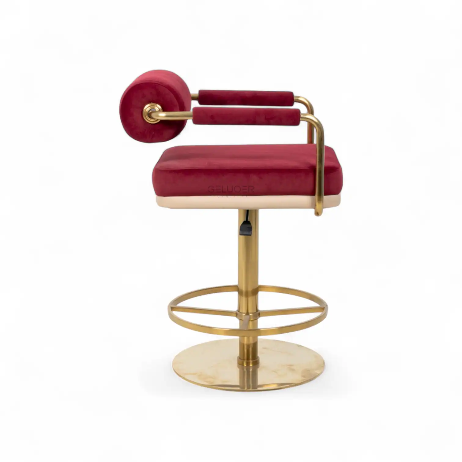 Red velvet upholstered vintage barber chair with gold metal accents for modern salon decor.