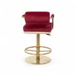 Luxurious red velvet bar stool with gold metal frame and footrest, stylish modern furniture for home bar.