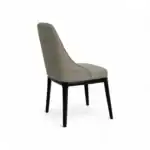 Upholstered beige quilted dining chair with black wooden legs for modern living rooms.
