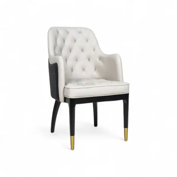 Elegant white quilted accent chair with black wooden legs and gold-tipped feet, stylishly designed for luxury furniture décor.