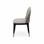 Elegant modern dining chair with upholstered beige seat and backrest, black legs with gold tips - perfect for luxury home decor.