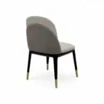 Luxurious modern dining chair with padded upholstery and stylish black and gold tapered legs.