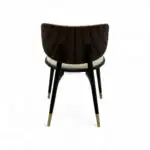 Elegant modern wooden dining chair with black and white upholstery and gold-tipped legs.