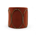 Elegant modern orange velvet ottoman with metallic decorative design, perfect for stylish home decor.