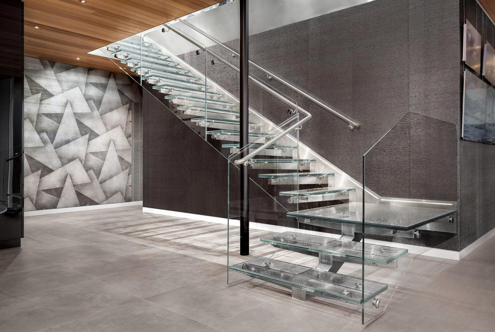 Interior staircase with stacked clear glass stair treads, glass side panels and stainless steel railings by Glass Flooring Systems
