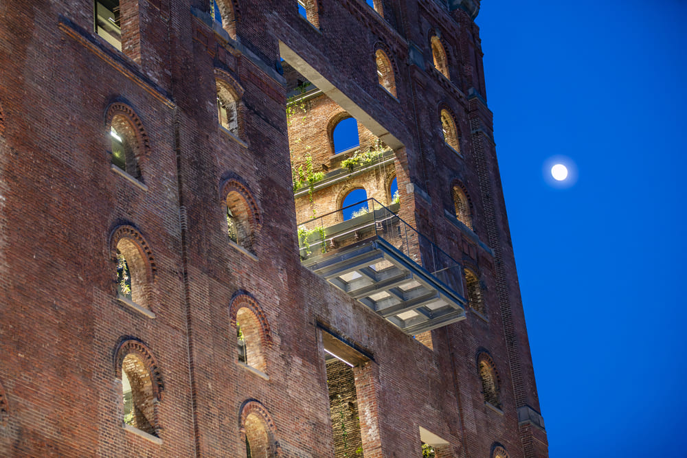Historic brick building at dusk with a cantilevered walkable glass balcony
