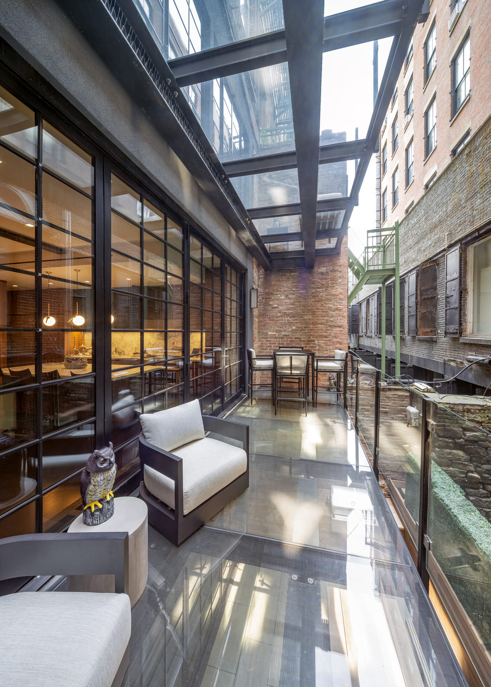Home interior at night with walkable glass floor panels beside a seating area