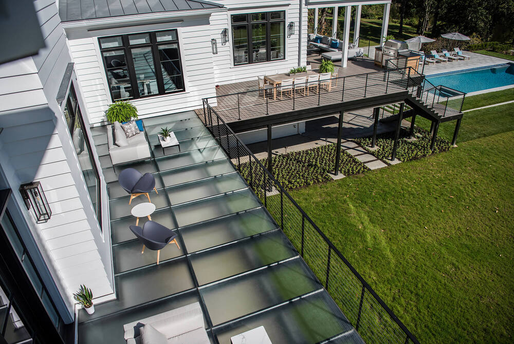 Glass deck with textured anti-slip walkable glass panels and wood decking leading to a backyard pool