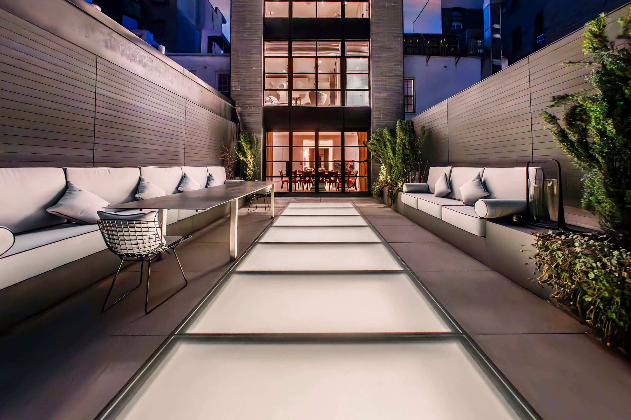Modern rooftop with a long walkable glass skylight walkway and outdoor seating