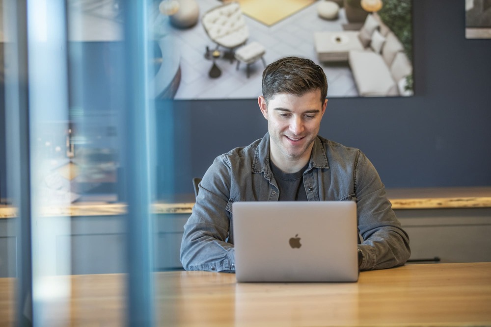 Glass Flooring Systems team member supporting a client project on a laptop