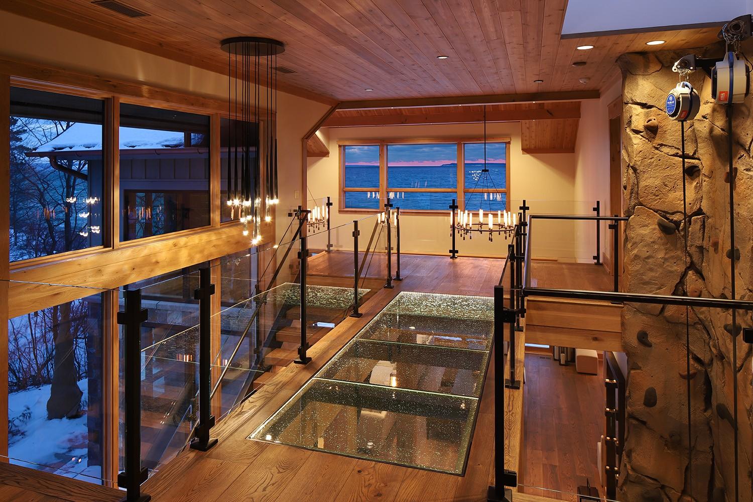 Interior glass bridge with walkable structural glass panels in a cabin-style home