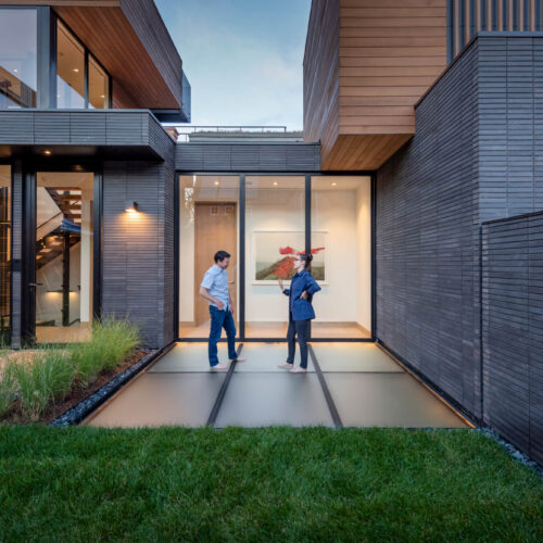 Contemporary Aspen residence at dusk with a flush SkyFloor Series 1000 walkable green roof skylight set into the lawn between the house wings