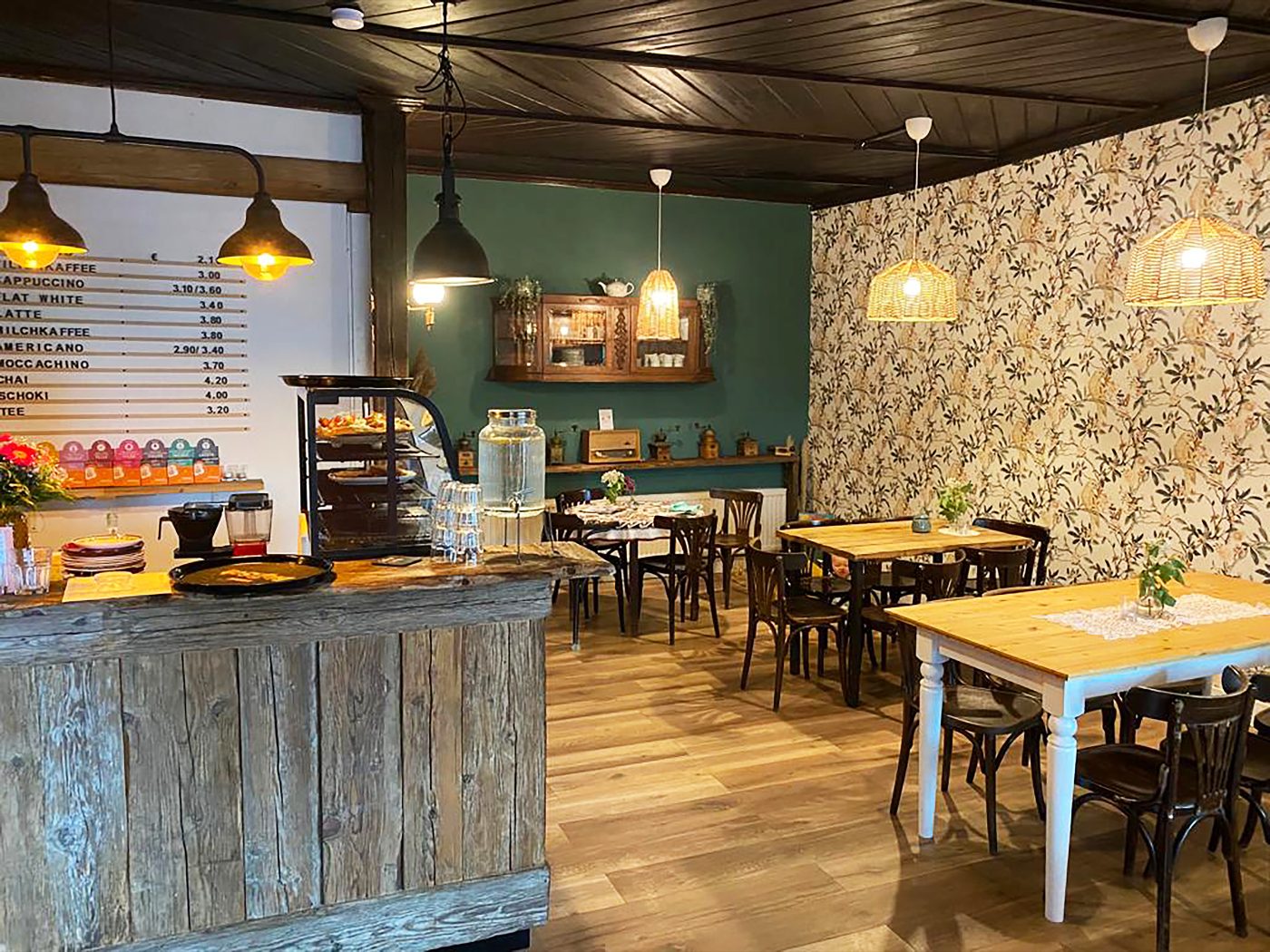 Innenraum des Cafés mit Theke und Tischen