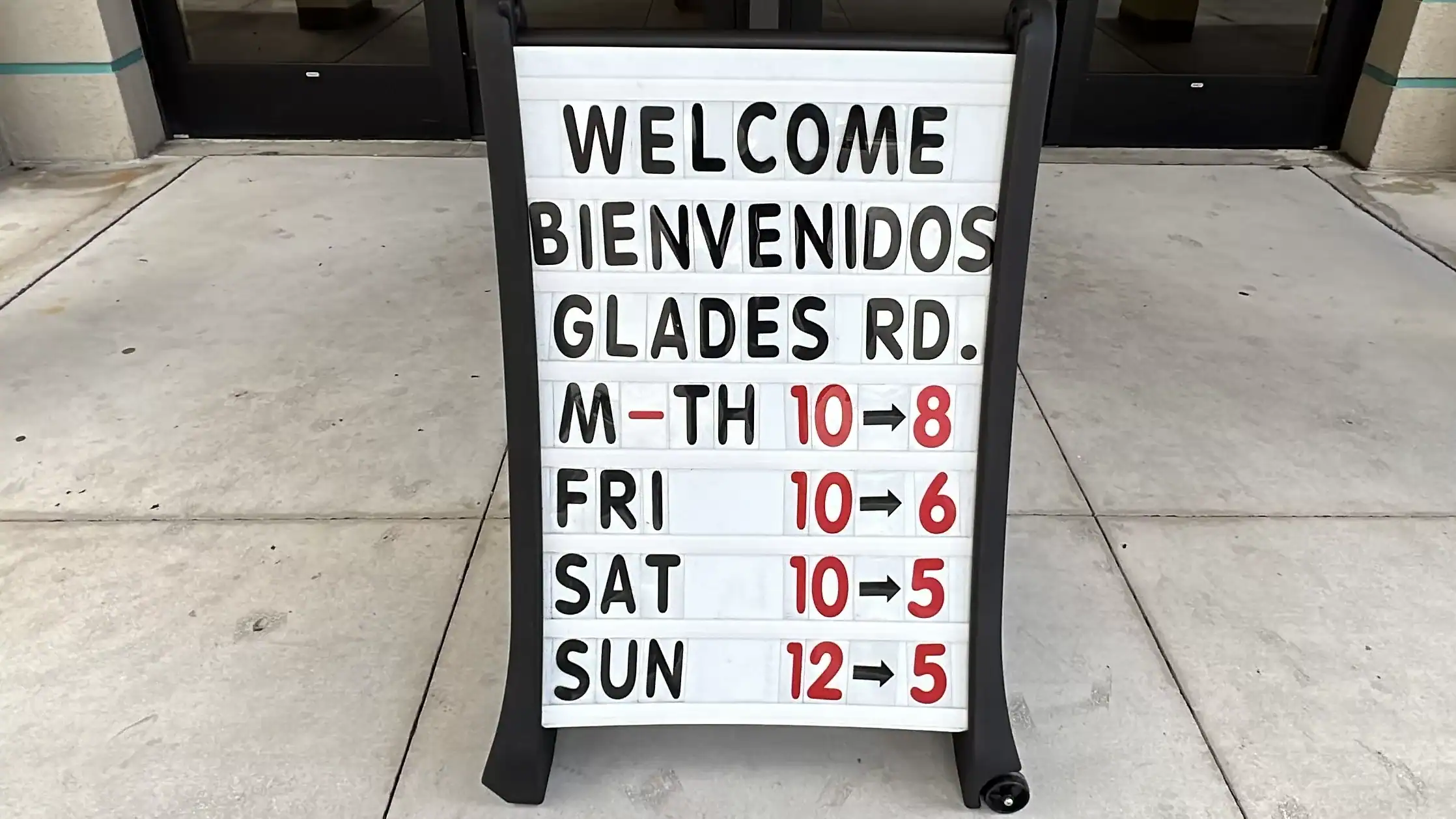 Sign showing the library hours of operation. Palm Beach County Library Glades Road GCNN Good Citizen News Network goodcitizennewsnetwork.com News That's Not Fake