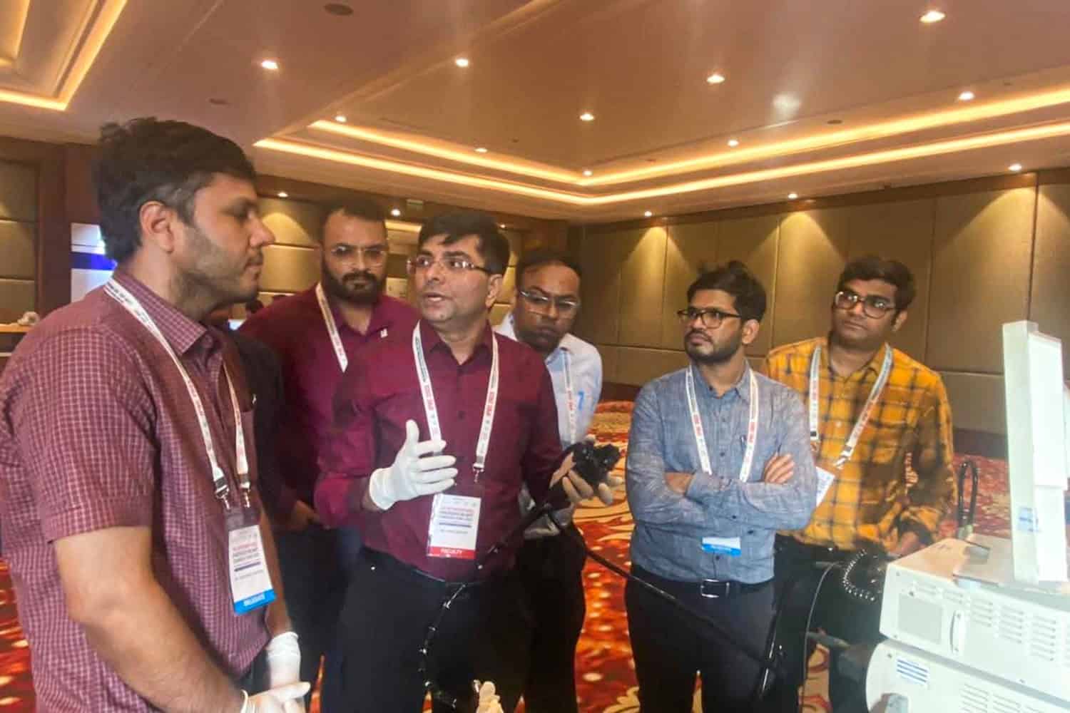 Dr. Rajiv Grover explaining medical equipment at a conference.