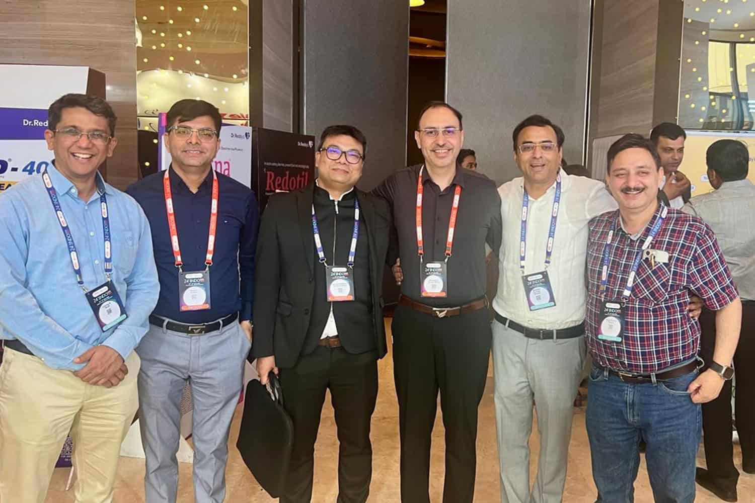Group of medical professionals at a conference, smiling and wearing badges.