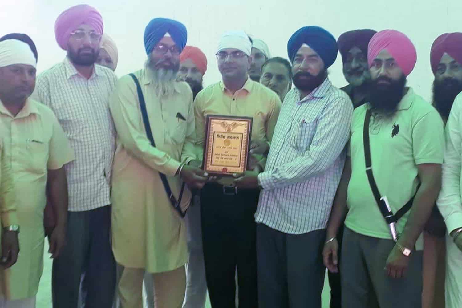 Group of men, including Dr. Rajiv Grover, receiving an award at an event.