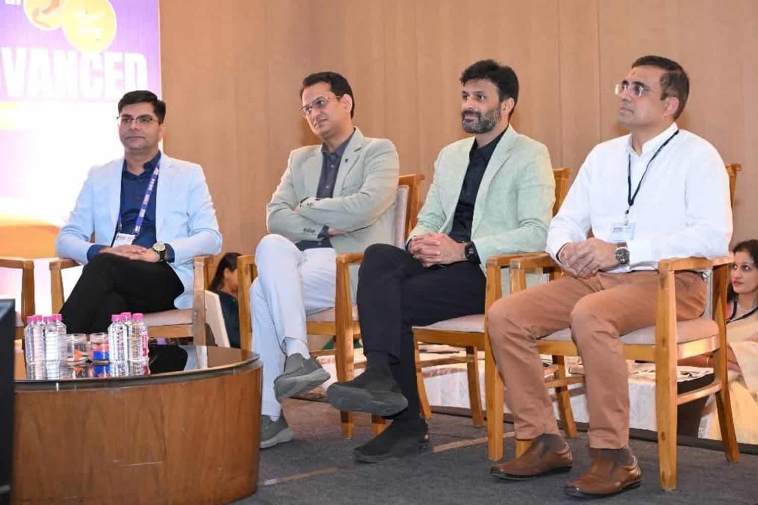 Panel of four professionals seated on stage at a conference.