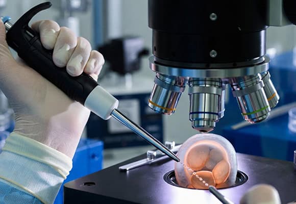 Fertility laboratory with advanced equipment and a technician working on a sample.