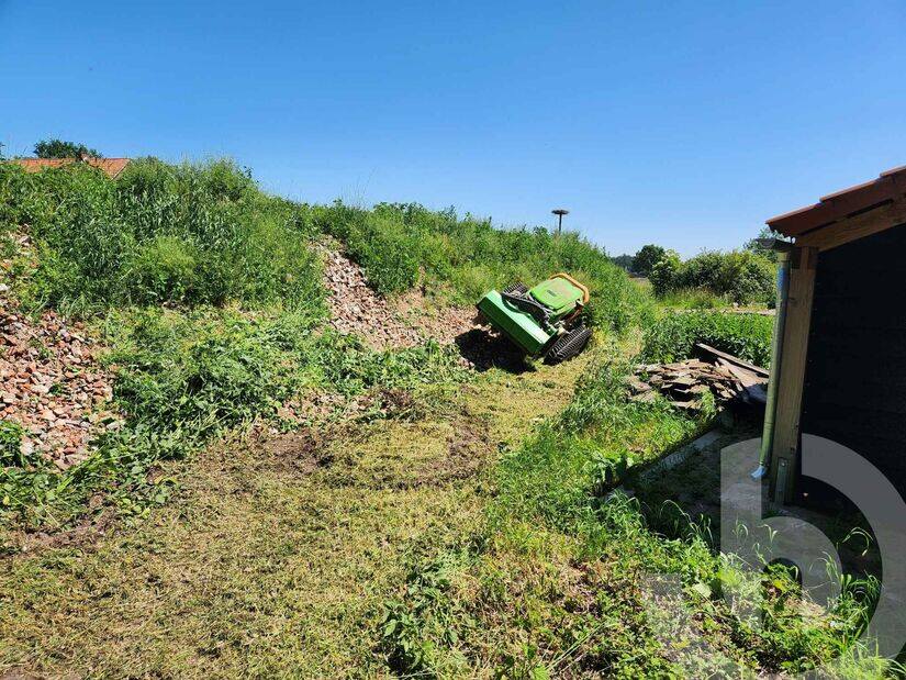 Funkraupe LV600 mit Grasmulcher beim Mähen und Mulchen von hohem Gras auf unebenem Gelände.