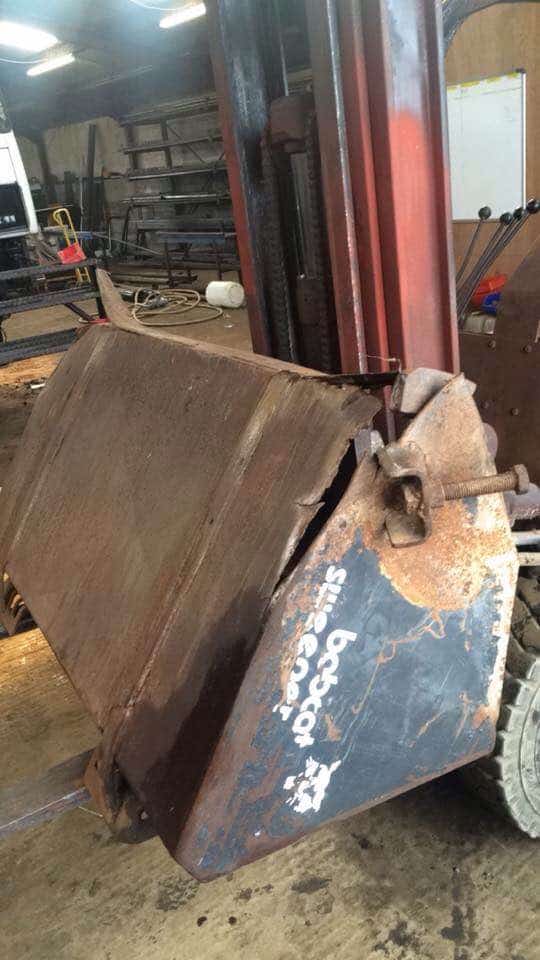 Rusty Bobcat loader bucket inside workshop