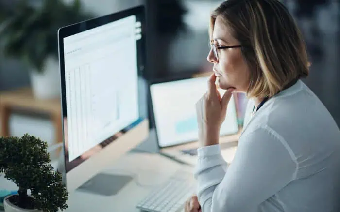 Businesswoman analyzing SharePoint data on computer screen.