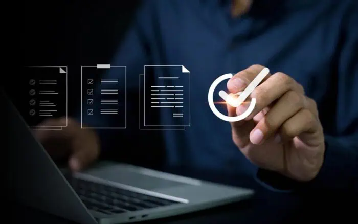 Business professional analyzing IT systems with digital icons and checklist.