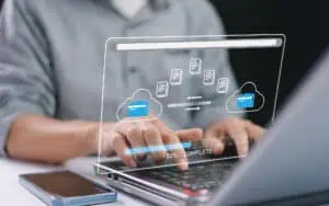 Business professional managing cloud data transfer on a transparent digital screen.