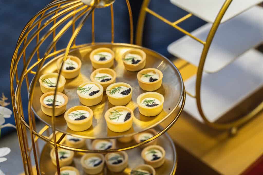 Elegant cup cake served on golden dessert tier tray at catering event