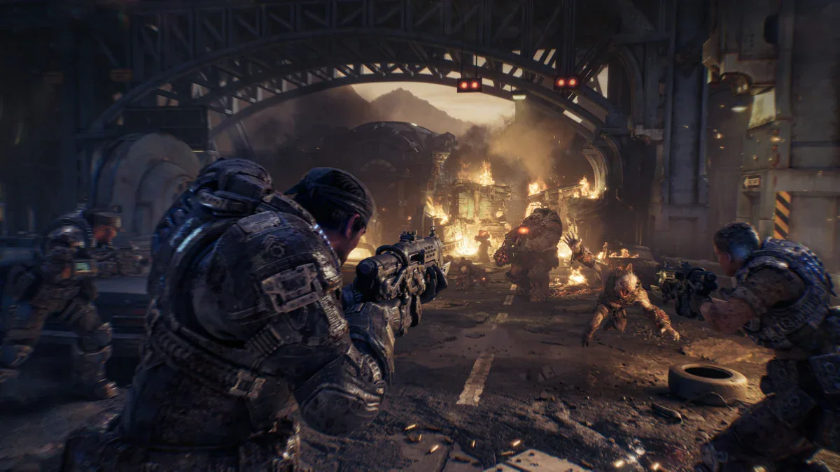 Marcus Fenix and Bravo Squad fight Locust under a burning bridge in Gears of War: E-Day