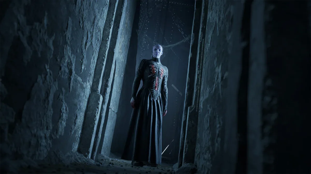 Pinhead stands at the end of a narrow stone corridor in Clive Barker's Hellraiser: Revival