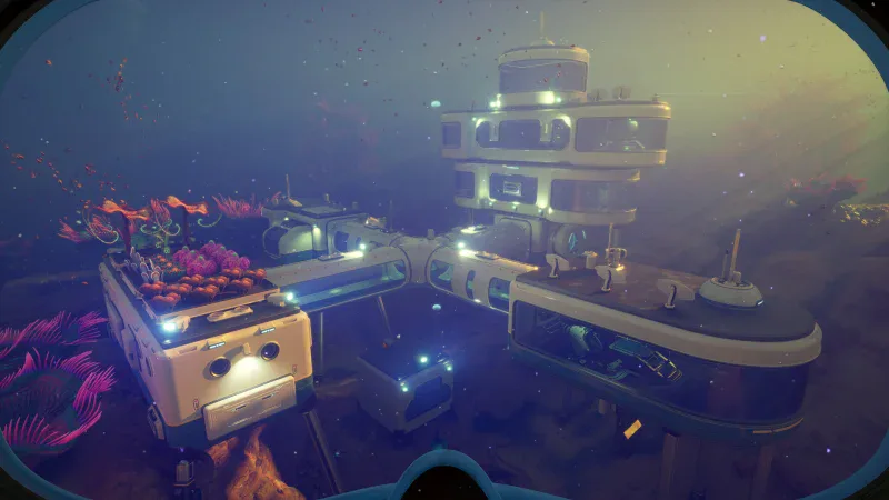 A lit multi-level underwater base on the seabed in Subnautica 2, seen through a dive mask