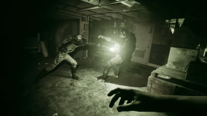 An enemy lunges through a dark room seen through night-vision goggles in The Outlast Trials