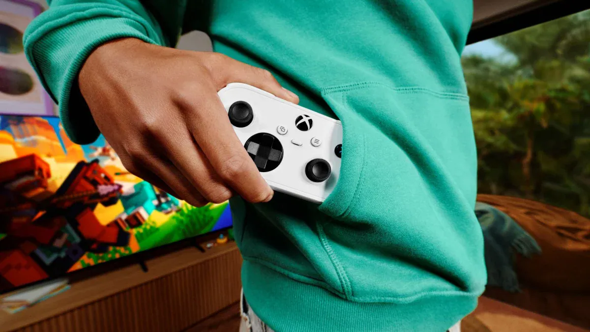 A player slips the white Xbox Nano Controller into a hoodie pocket