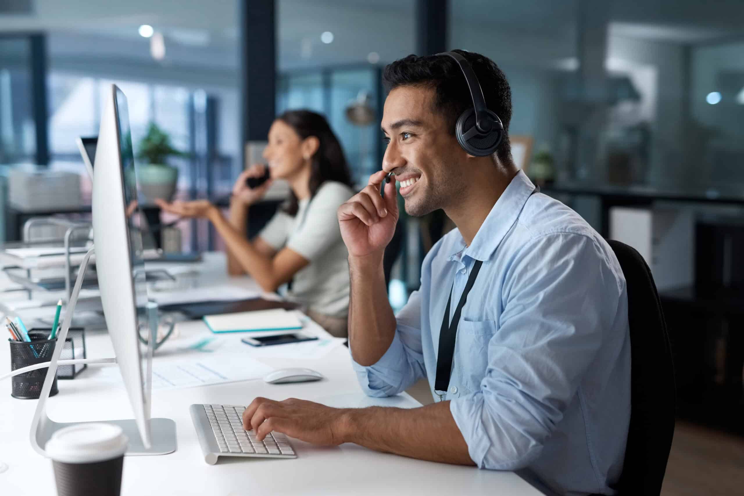 Person wearing headphones working at computer in modern office.