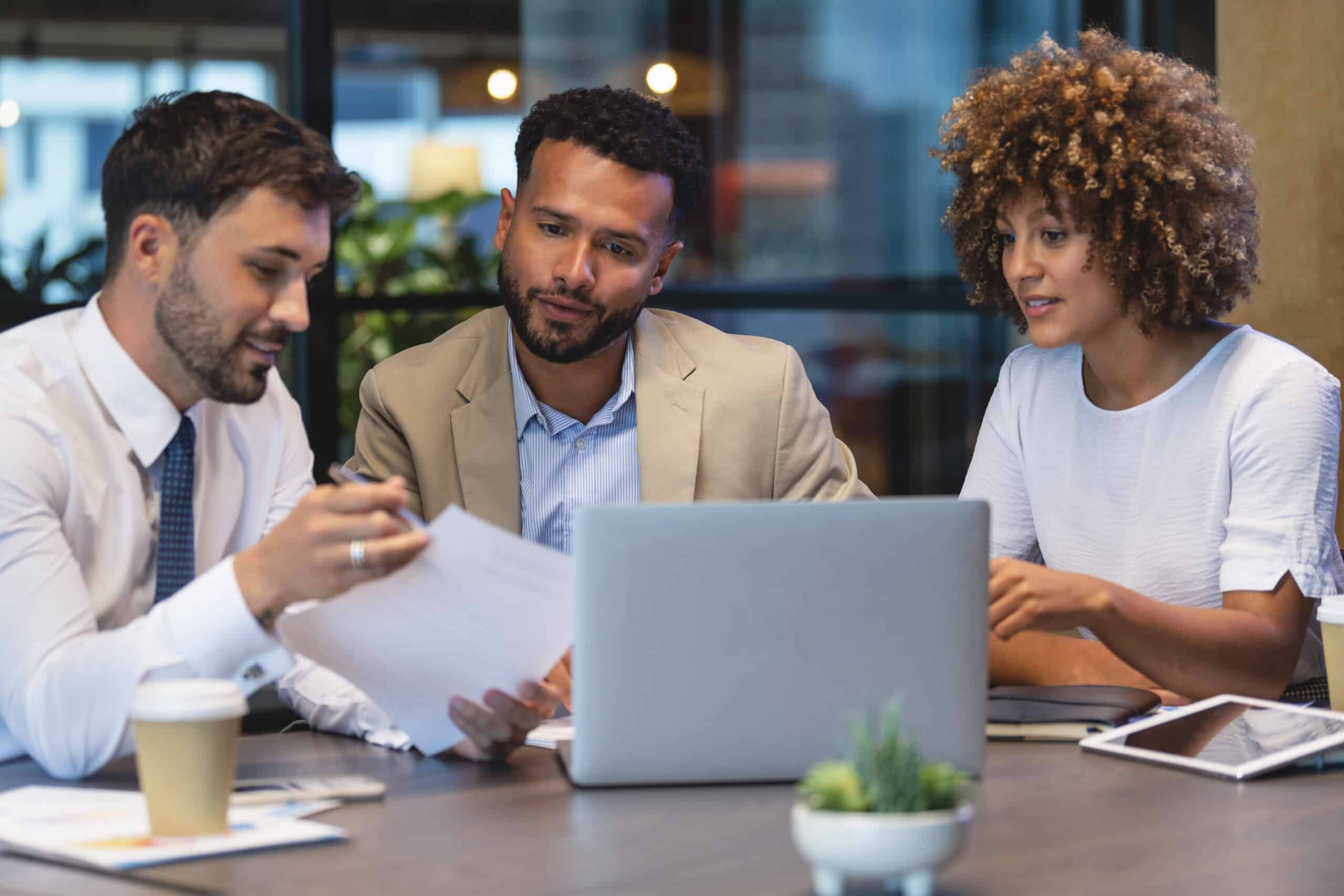 Diverse business professionals discussing strategies during a meeting at a modern office.