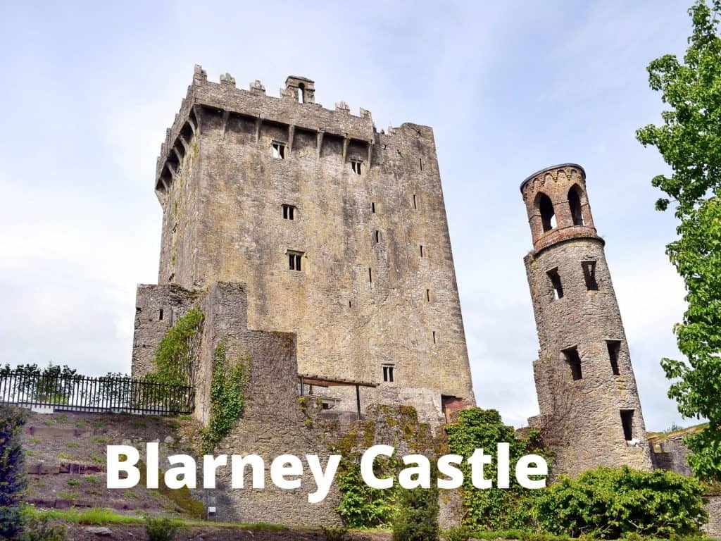 Medieval Blarney Castle in Ireland with stone towers and lush green surroundings.