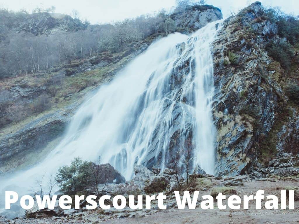 Breathtaking Powerscourt Waterfall in Ireland, surrounded by rugged nature and lush greenery.