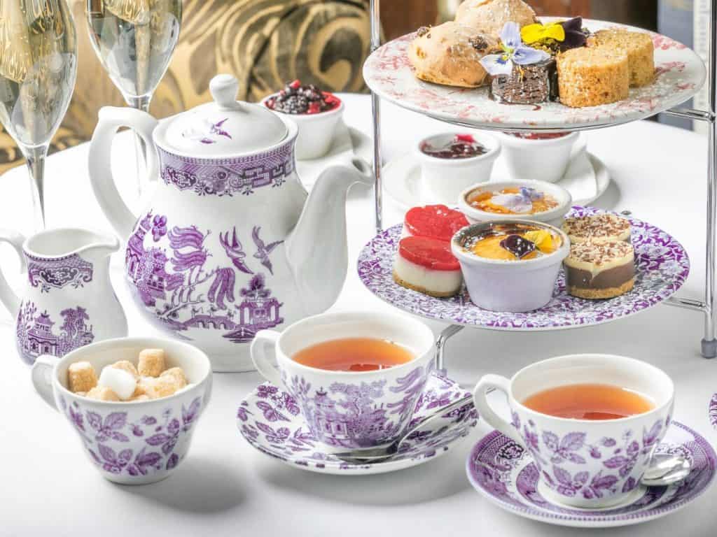 Delicate china teapot and cups with a traditional Irish afternoon tea spread.