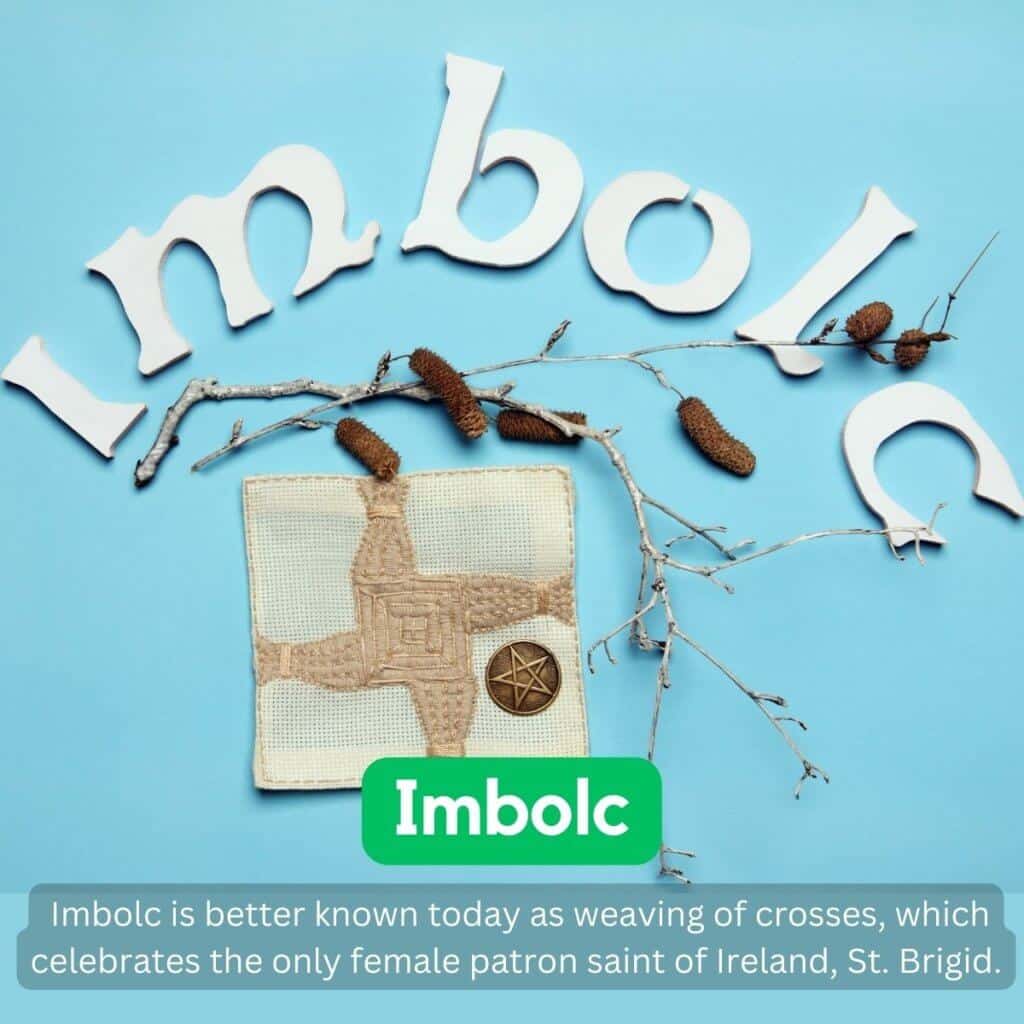 Handmade Irish embroidered cross with cross-stitch pattern and Celtic medal on light blue background.