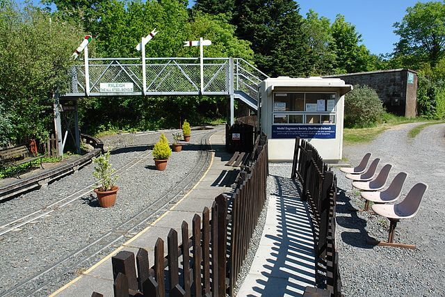 Miniature railway station with waiting area and potted plants, perfect for Irish heritage and leisure travel.